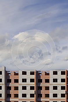 Construction of a multi-storey building. Building house on blue sky background.