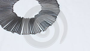 Construction nails lie around on a white background. Steel nails are laid out in the form of a frame with space for text. A pile o