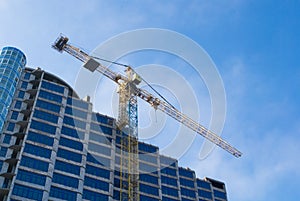 Construction - new blue glass building and crane