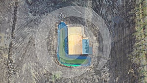 construction of new building with small pond in spring, aerial