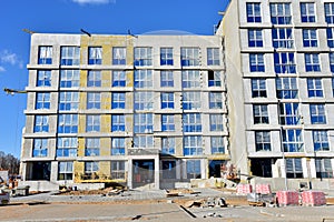 Construction of a new multi-storey building. Suspended cradle for works insulation of the facade of the mineral wool. Laying