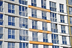 Construction of a new multi-storey building. Wall painting and insulation of the facade of the mineral wool.  Modern residential