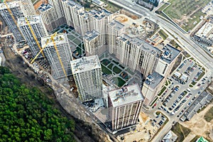 Construction of new residential district near city park. cranes and other industrial equipment working on construction site.