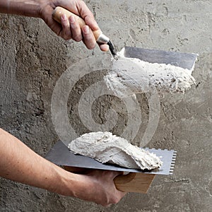 Construction notched trowel and worker hands