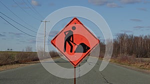 Construction orange traffic sign on rural road clouds time lapse