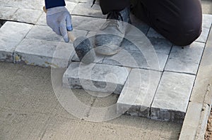 Construction of pavement near the house. Bricklayer places concrete paving stone blocks for building up a Sidewalk