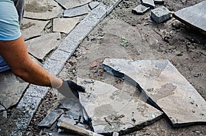 Construction of pavement near the house. Bricklayer places concrete paving stone blocks for building up a Sidewalk