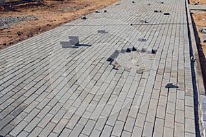 Construction of pavement near the house. Bricklayer places concrete paving stone blocks for building up a Sidewalk pavement