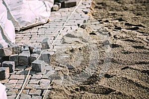 Construction of pavement road or sidewalk with cobblestone granite stones in urban city. terrace pavement details photo