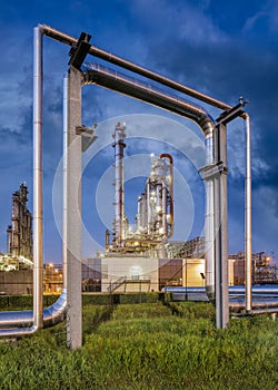Construction with pipeline and Illuminated petrochemical production plant.