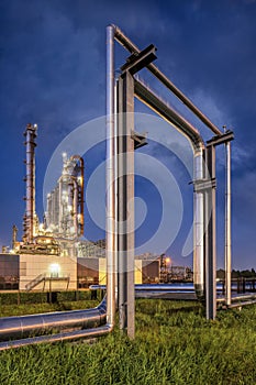 Construction with pipeline and Illuminated petrochemical production plant.