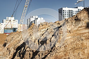 Construction pit with high-rise buildings in the background. Construction site in the city. Pit for the construction of an