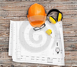 Construction plans with helmet and drawing tools on blueprints .