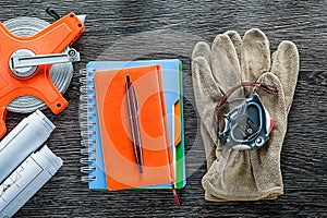 Construction plans measuring tape protective gloves notepads pen