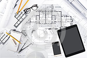 Construction plans with Tablet and drawing Tools on blueprints