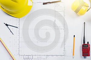 Construction plans with yellow helmet and drawing
