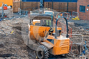 Construction plant and machinery. Dumper and excavator working on new homes construction site