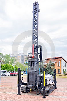 Construction platform on rubber crawler tracks with a winch, metal boom and vertical lifting mechanism