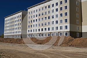 Construction process and development of house area, land grading or earthwork, facade of a new multi-storey building