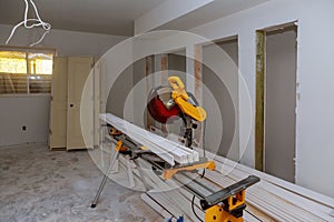 Construction remodeling home cutting wooden trim board on with circular saw