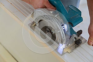 Construction remodeling home cutting wooden trim board on with hand circular saw