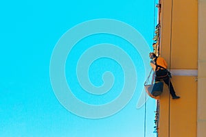 Construction and renovation background. Worker climbing on the wall
