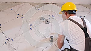 Construction and repair of an apartment. A man installs ceramic tiles in a new apartment.