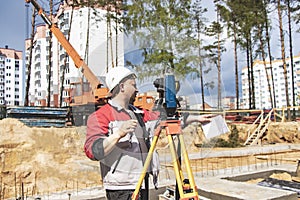 Construction of a residential area. Geodetic stakeout. Surveyor at a large construction site. A man with a tachometer during work