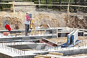 Construction of a residential area. Geodetic stakeout. Surveyor at a large construction site. A man with a tachometer during work