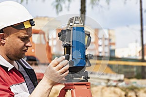 Construction of a residential area. Geodetic stakeout. Surveyor at a large construction site. A man with a tachometer during work