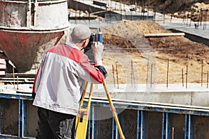 Construction of a residential area. Geodetic stakeout. Surveyor at a large construction site. A man with a tachometer during work photo