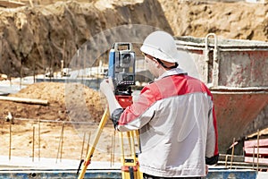 Construction of a residential area. Geodetic stakeout. Surveyor at a large construction site. A man with a tachometer during work