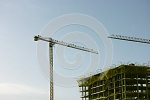 Construction of a residential high-rise multistory modern house building in a metropolis city. Construction crane on