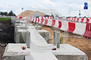 construction of road junction at the viaduct with concrete barriers and red white plastic stops near the .