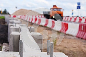 construction of road junction at the viaduct with concrete barriers and red white plastic stops near the .