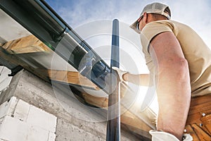 Construction Roof Worker Installing House Gutters