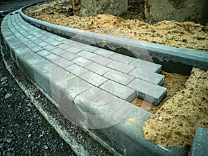 Construction of a sidewalk from paving slabs and concrete curbs