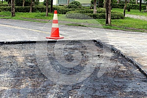 Construction sign and traffic cone on road
