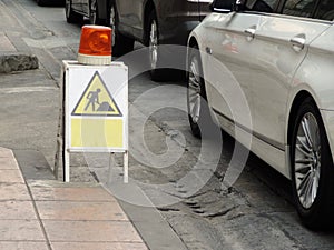 Construction sign with Yellow orange siren light rotary warning light in construction site safety sign, installed beside road