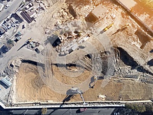 Construction site aerial view. Mall building base with solid concrete pillars. Heavy machinery piling and high tower crane working