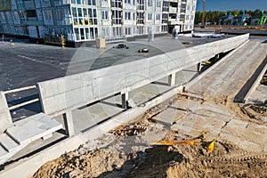 Construction site with a building in progress and machinery near a road, showing infrastructure development