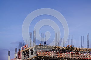 Construction site building with workers on blue sky background copy space.