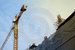 Construction site building with yellow cranes on sky with cloud