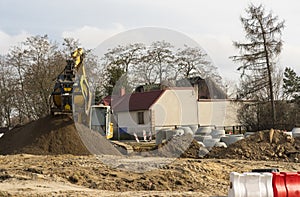 Construction site in the city. Crawler excavator heaps of earth, sand and rubble.