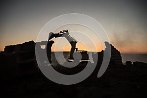 Construction site on a city street. A yellow digger excavator parked during the night on a construction site. Industrial concept t