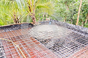 Construction site: Concrete from bucket loaded to roof slab formwork and reinforcement bar