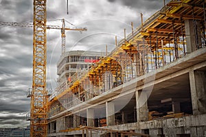 Construction site. Construction cranes, monolithic concrete wall