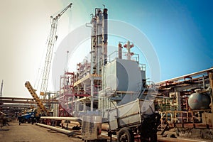 Construction site for the construction of an oil refinery with rectification columns, heat exchangers a crane at an oil refinery