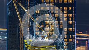 Construction site with crane at JBR night timelapse. Building of skyscrapers.