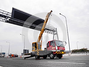 Construction site crane is lifting a led signboard for advertisement